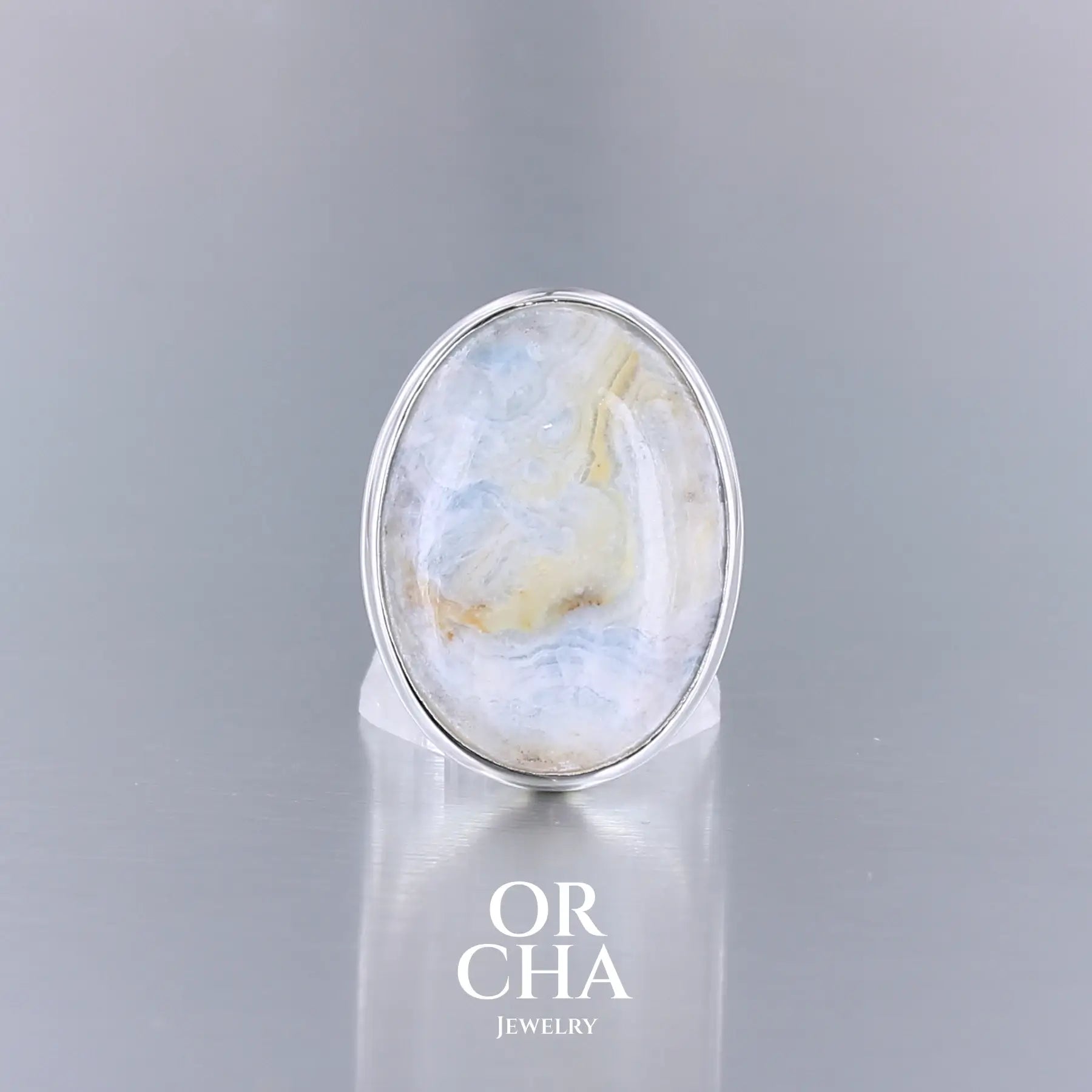 Bague ovale pour femme en argent massif sertie d'une scheelite bleue. Pierre naturelle de couleur bleu, beige creme et blanc de qualité  opaque. Taille 56. Bijoux unique, éthique et durable présenté dans un coffret de notre marque, prêt à offrir. Livraison offerte, certificat d'authenticité, service client.