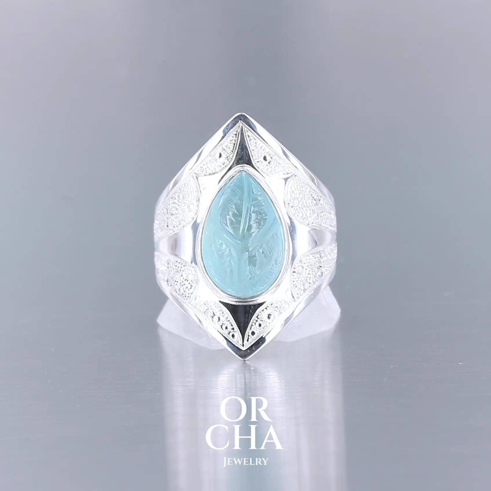 Bague pour femme en argent massif sculptées d'étoiles et autres corps célestes sertie d'une topaze bleue sculptée. Pierre cabochon en forme de goutte de couleur bleu ciel lumineux. Bague réalisée en taille 60. Bijoux unique, éthique et durable présenté dans un coffret de notre marque, prêt à offrir. Livraison offerte, certificat d'authenticité, service client.