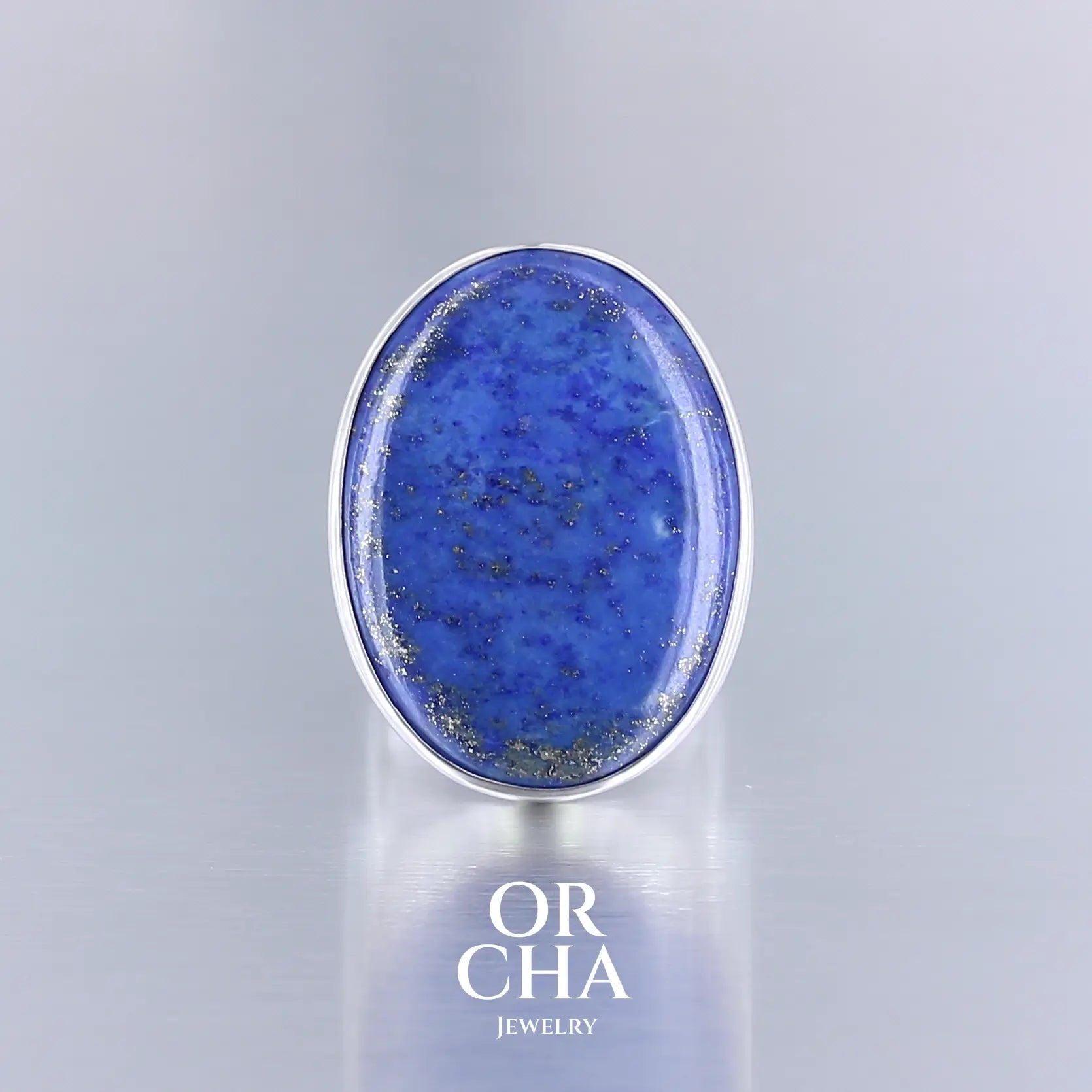 Bague ovale pour femme en argent massif sertie d'un Lapis Lazuli. Pierre naturelle de couleur bleu nuit à inclusions de pyrite dorés, qualité  opaque. Taille 59. Bijoux unique, éthique et durable présenté dans un coffret de notre marque, prêt à offrir. Livraison offerte, certificat d'authenticité, service client.