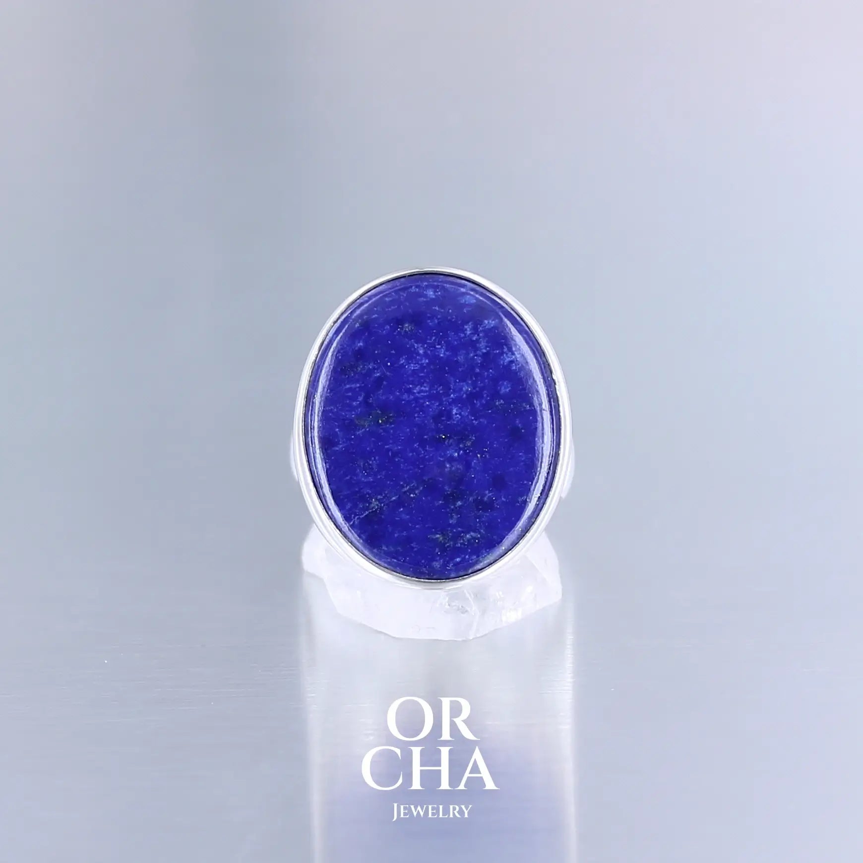 Bague ovale pour femme en argent massif sertie d'un Lapis Lazuli. Pierre naturelle de couleur bleu nuit à inclusions de pyrite dorés, qualité  opaque. Taille 56. Bijoux unique, éthique et durable présenté dans un coffret de notre marque, prêt à offrir. Livraison offerte, certificat d'authenticité, service client.