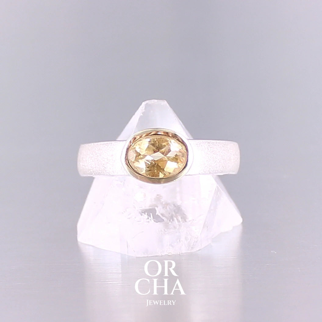 Bague anneau pour femme en argent massif et or sertie d'une Citrine. Pierre facettée de forme ovale, de qualité transparente, propre à l'oeil. Pierre naturelle de couleur jaune doré lumineux. Bijoux unique, éthique et durable présenté dans un coffret de notre marque, prêt à offrir. Livraison offerte, certificat d'authenticité, service client.
