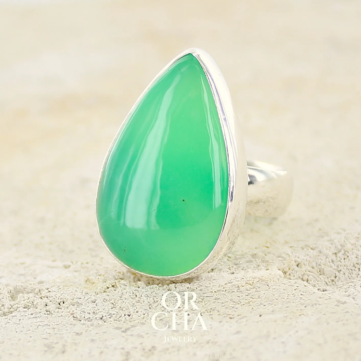 Bague pour femme en argent massif, sertie d'un cabochon de Chrysoprase. Pierre taillée en forme de goutte de qualité opaque. Bijoux unique réalisé en taille 58 par Orcha Jewelry