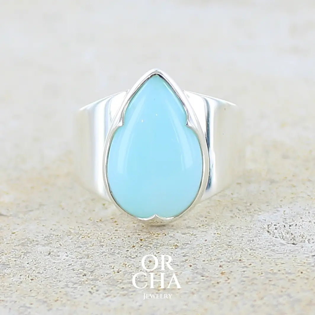 Bague pour femme en argent massif, sertie d'un cabochon d'opale bleue du Pérou de couleur bleu ciel. Pierre taillée en forme de goutte de qualité opaque. Bijou unique de taille 56