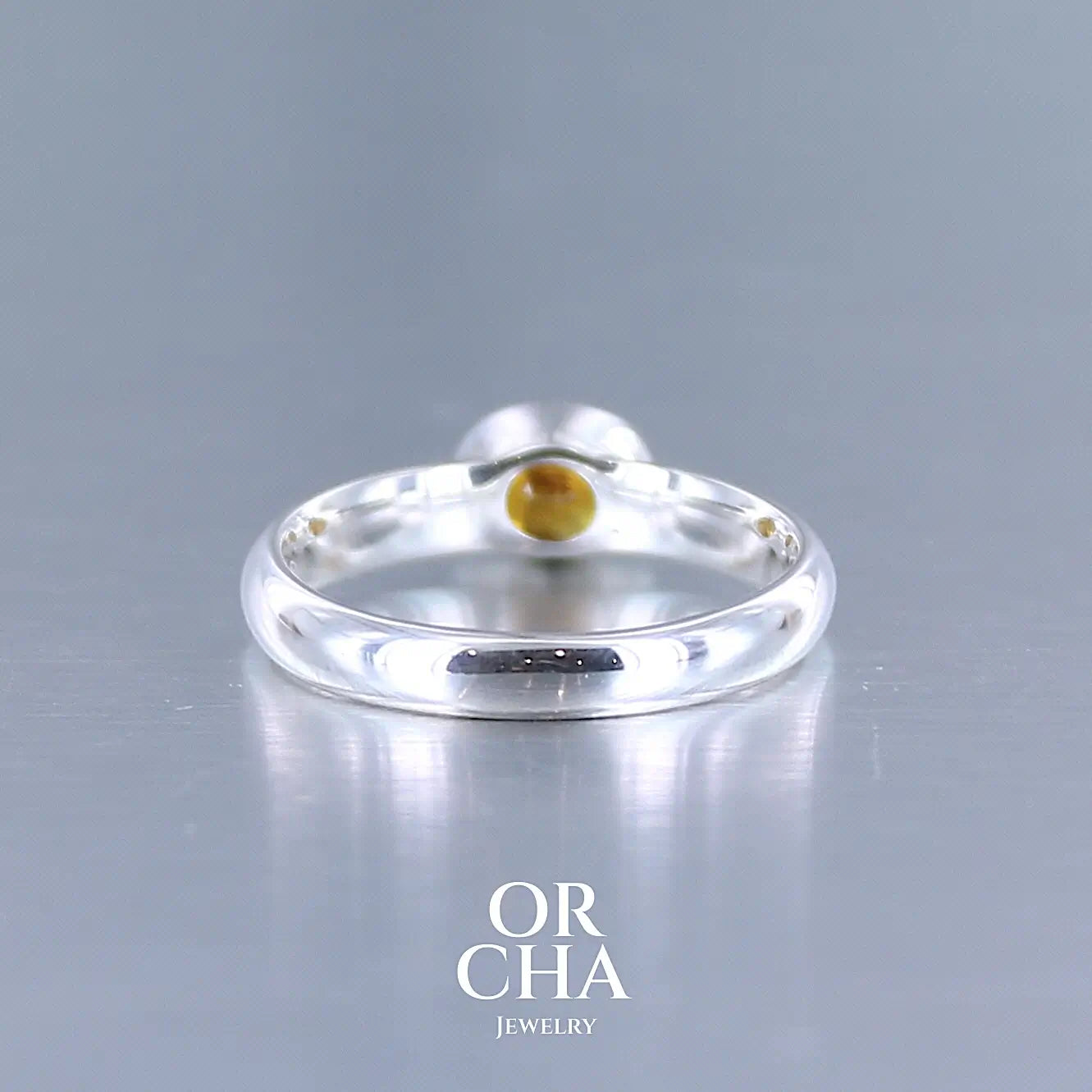 photo de profil d'une bague anneau en argent massif sertie d'un Saphir orange. Pierre facettée de forme ovale de qualité transparente, propre à l'oeil. Pierre chauffe et traité au beryllium de couleur orange intense. Tailles 56. Pour homme et femme. Bijoux unique, éthique et durable présenté dans un coffret de notre marque, prêt à offrir. Livraison offerte, certificat d'authenticité, service client.