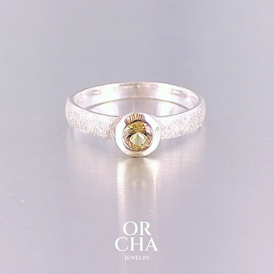 Bague anneau pour femme en argent massif et or sertie d'une Héliodore. Pierre facettée de forme ronde, de qualité transparente, propre à l'oeil. Pierre naturelle de couleur jaune doré lumineux. Bijoux unique, éthique et durable présenté dans un coffret de notre marque, prêt à offrir. Livraison offerte, certificat d'authenticité, service client.
