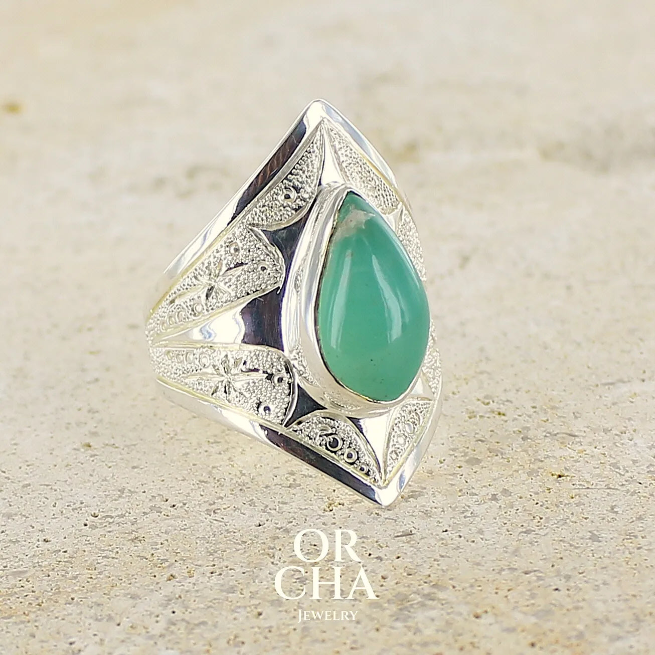 Grande Bague marquise pour femme en argent massif, sertie d'un cabochon de calcédoine bleue verte. Pierre taillée de en forme de goutte. Pierre translucide. bijou unique réalisée en taille 54 par Orcha Jewelry