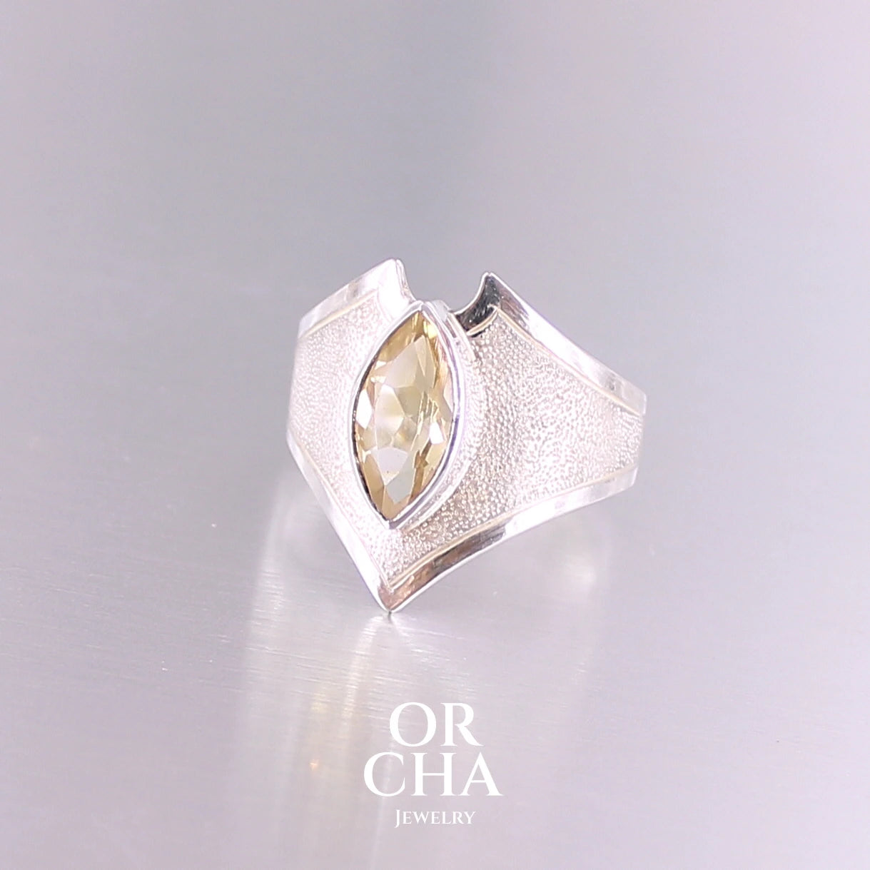 Bague contemporaine en forme pour femme en argent massif sertie d'une Citrine. Pierre facettée en forme de marquise de qualité transparente, propre à l'oeil. Pierre naturelle de couleur jaune doré lumineux. Bijoux unique, éthique et durable présenté dans un coffret de notre marque, prêt à offrir. Livraison offerte, certificat d'authenticité, service client.