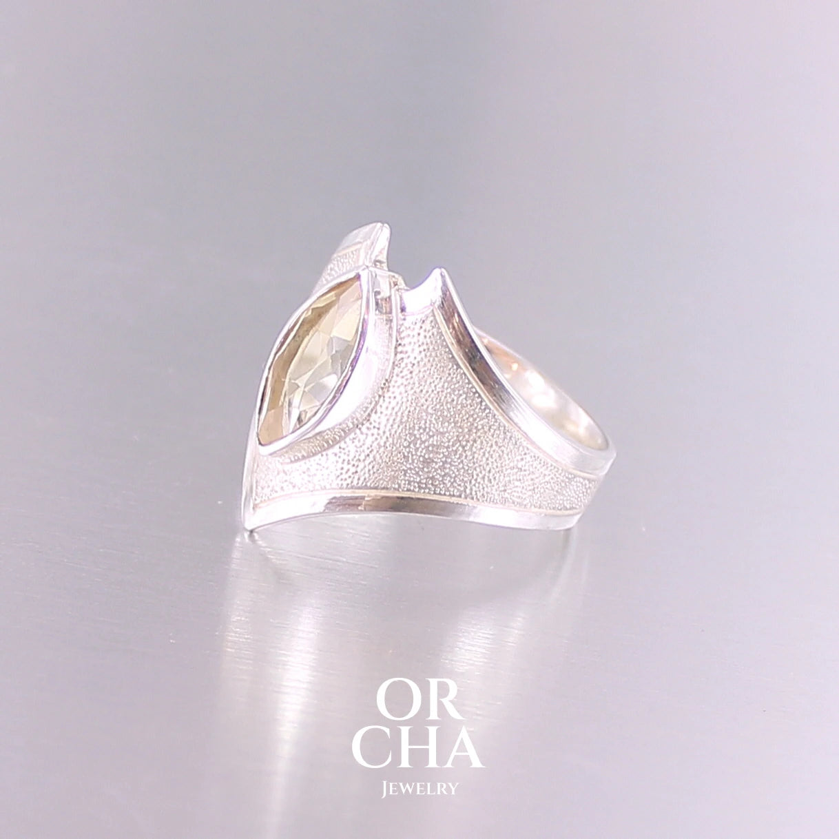 Bague contemporaine en forme pour femme en argent massif sertie d'une Citrine. Pierre facettée en forme de marquise de qualité transparente, propre à l'oeil. Pierre naturelle de couleur jaune doré lumineux. Bijoux unique, éthique et durable présenté dans un coffret de notre marque, prêt à offrir. Livraison offerte, certificat d'authenticité, service client.
