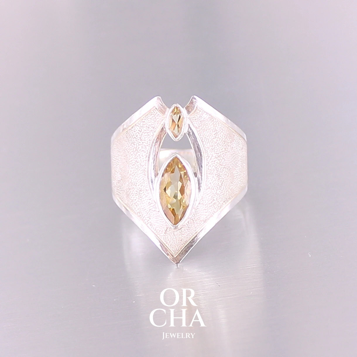 Grande bague contemporaine pour femme en argent massif sertie de Citrines. Pierre facettée en forme de marquise de qualité transparente, propre à l'oeil. Pierre naturelle de couleur jaune doré lumineux. Bijoux unique, éthique et durable présenté dans un coffret de notre marque, prêt à offrir. Livraison offerte, certificat d'authenticité, service client.