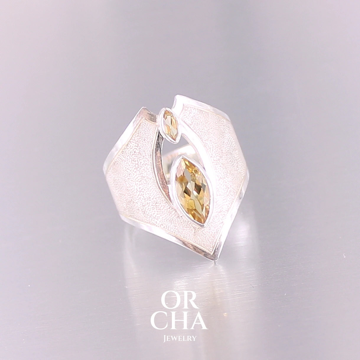 Grande bague contemporaine pour femme en argent massif sertie de Citrines. Pierre facettée en forme de marquise de qualité transparente, propre à l'oeil. Pierre naturelle de couleur jaune doré lumineux. Bijoux unique, éthique et durable présenté dans un coffret de notre marque, prêt à offrir. Livraison offerte, certificat d'authenticité, service client.