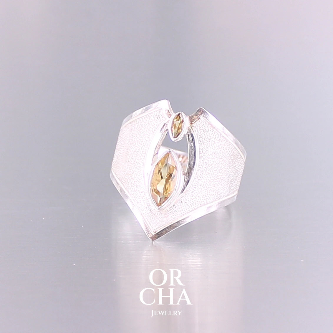Grande bague contemporaine pour femme en argent massif sertie de Citrines. Pierre facettée en forme de marquise de qualité transparente, propre à l'oeil. Pierre naturelle de couleur jaune doré lumineux. Bijoux unique, éthique et durable présenté dans un coffret de notre marque, prêt à offrir. Livraison offerte, certificat d'authenticité, service client.
