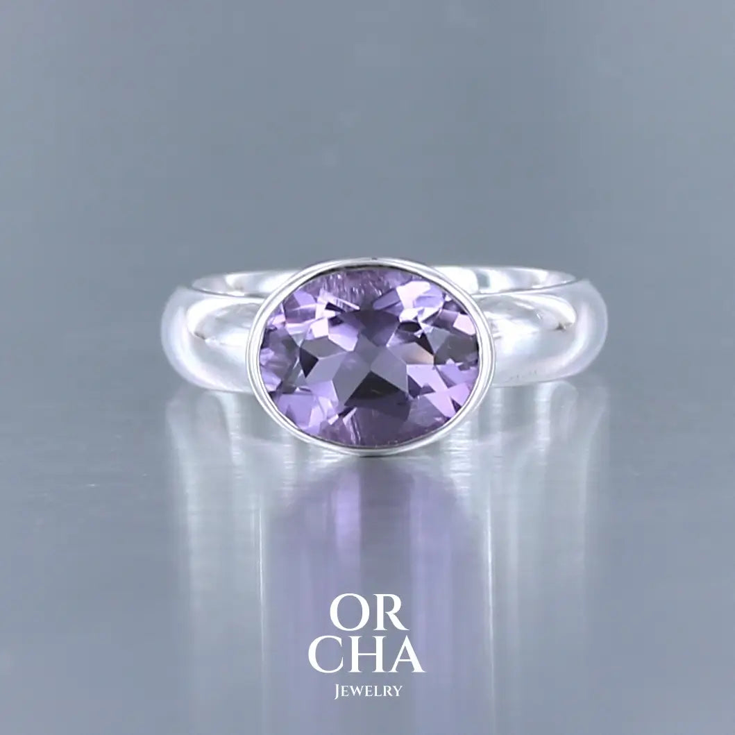 Bague minimaliste pour femme en argent massif sertie d'une Améthyste. Pierre facettée de forme ovale de qualité transparente, propre à l'oeil. Pierre naturelle de couleur violette clair type rose de France. Tailles 58. Bijoux unique, éthique et durable présenté dans un coffret de notre marque, prêt à offrir. Livraison offerte, certificat d'authenticité, service client.
