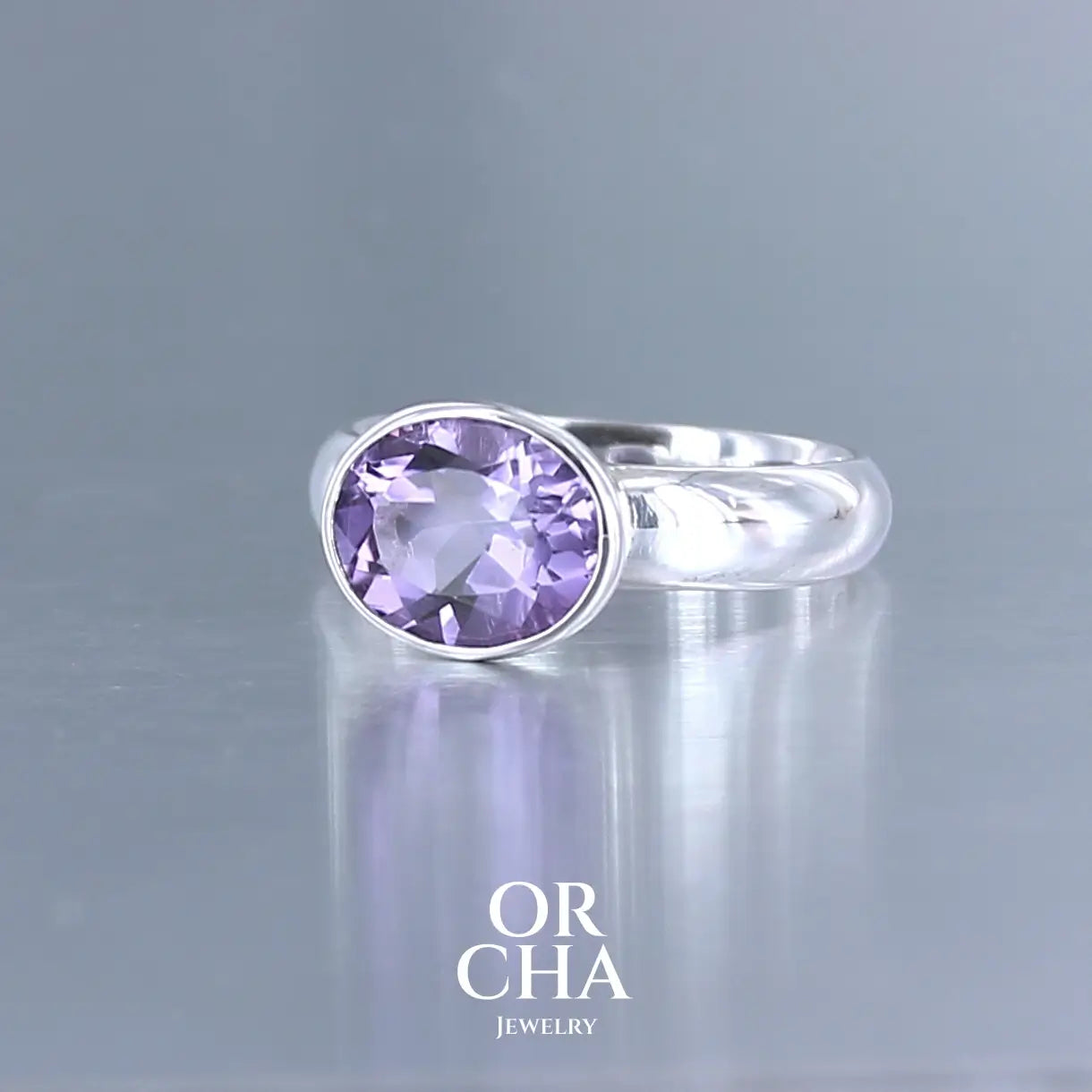Bague minimaliste pour femme en argent massif sertie d'une Améthyste. Pierre facettée de forme ovale de qualité transparente, propre à l'oeil. Pierre naturelle de couleur violette clair type rose de France. Tailles 58. Bijoux unique, éthique et durable présenté dans un coffret de notre marque, prêt à offrir. Livraison offerte, certificat d'authenticité, service client.