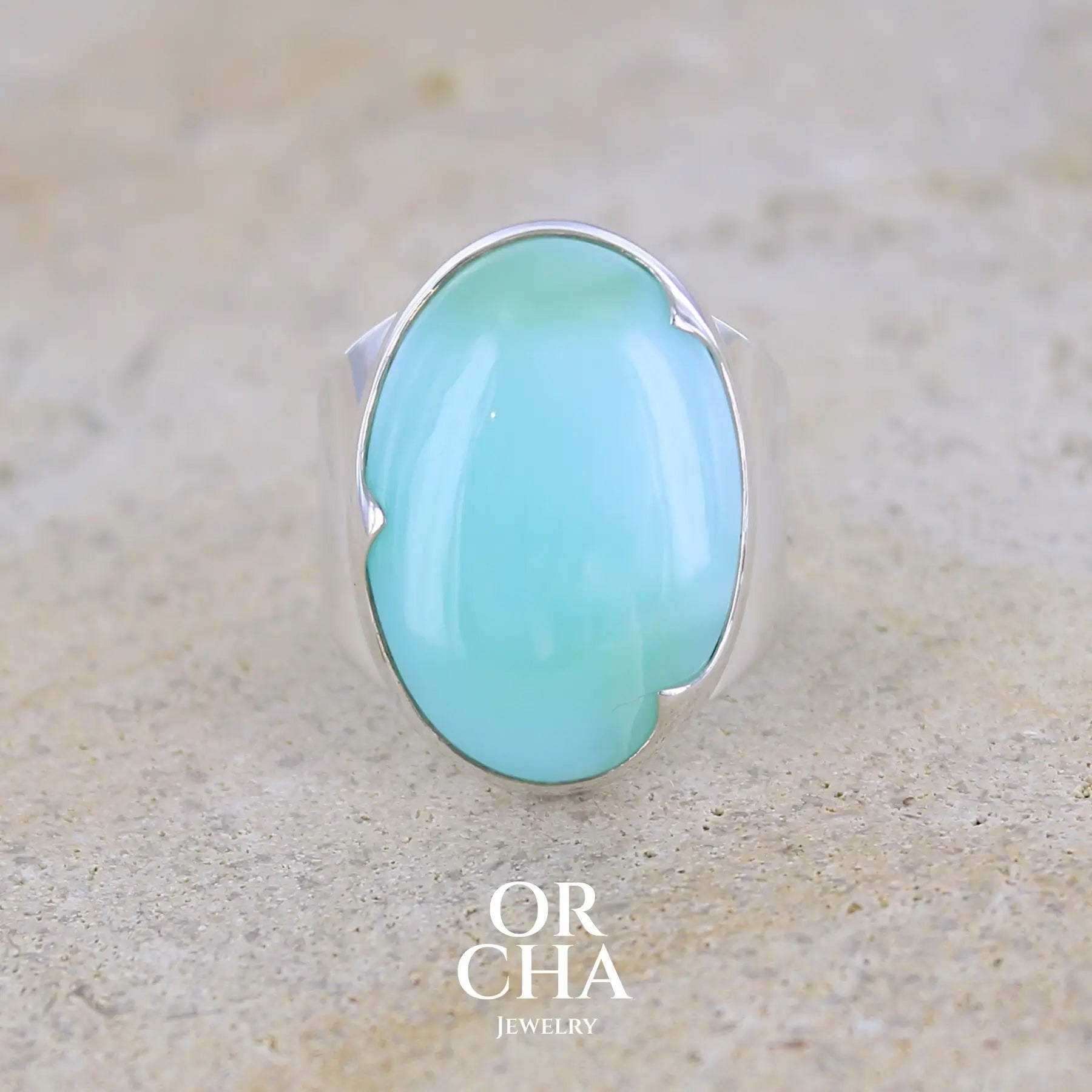 Grande Bague pour femme en argent massif, sertie d'un cabochon d'opale bleue du Pérou. Pierre taillée de forme ovale. Pierre opaque. Taille 58,5. Bijoux unique, éthique et durable présenté dans un coffret de notre marque, prêt à offrir. Livraison offerte, certificat d'authenticité, service client.
