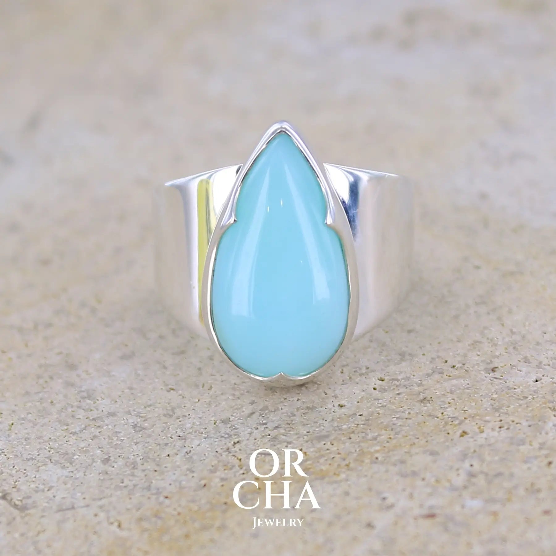Bague pour femme en argent massif, sertie d'un cabochon d'opale bleue du Pérou. Pierre taillée en forme de longue goutte. Pierre opaque. Taille 54. Bijoux unique, éthique et durable présenté dans un coffret de notre marque, prêt à offrir. Livraison offerte, certificat d'authenticité, service client.