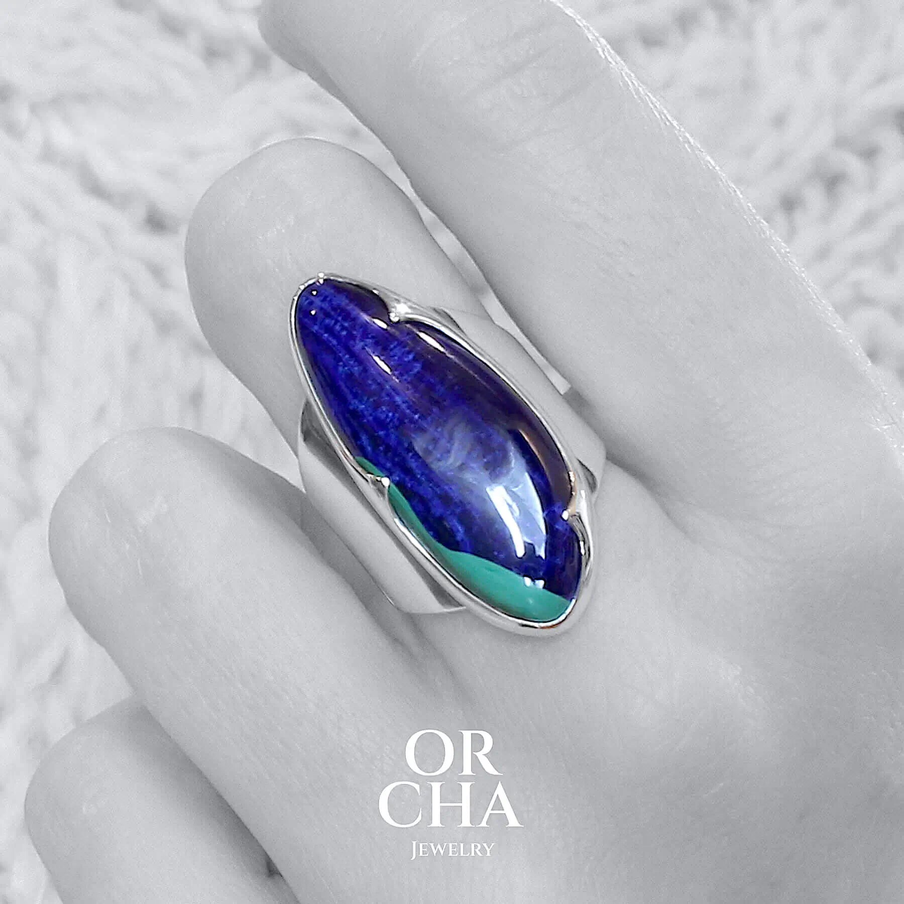 Grande bague, protée sur une main, pour femme en argent massif sertie d'une Azurite d'une superbe qualité. Pierre cabochon en forme libre, pierre naturelle de couleur bleu profond intense avec une petite tache verte de malachite. Pierre fine de qualité opaque. Taille 56. Bijoux unique, éthique et durable présenté dans un coffret de notre marque, prêt à offrir. Livraison offerte, certificat d'authenticité, service client.
