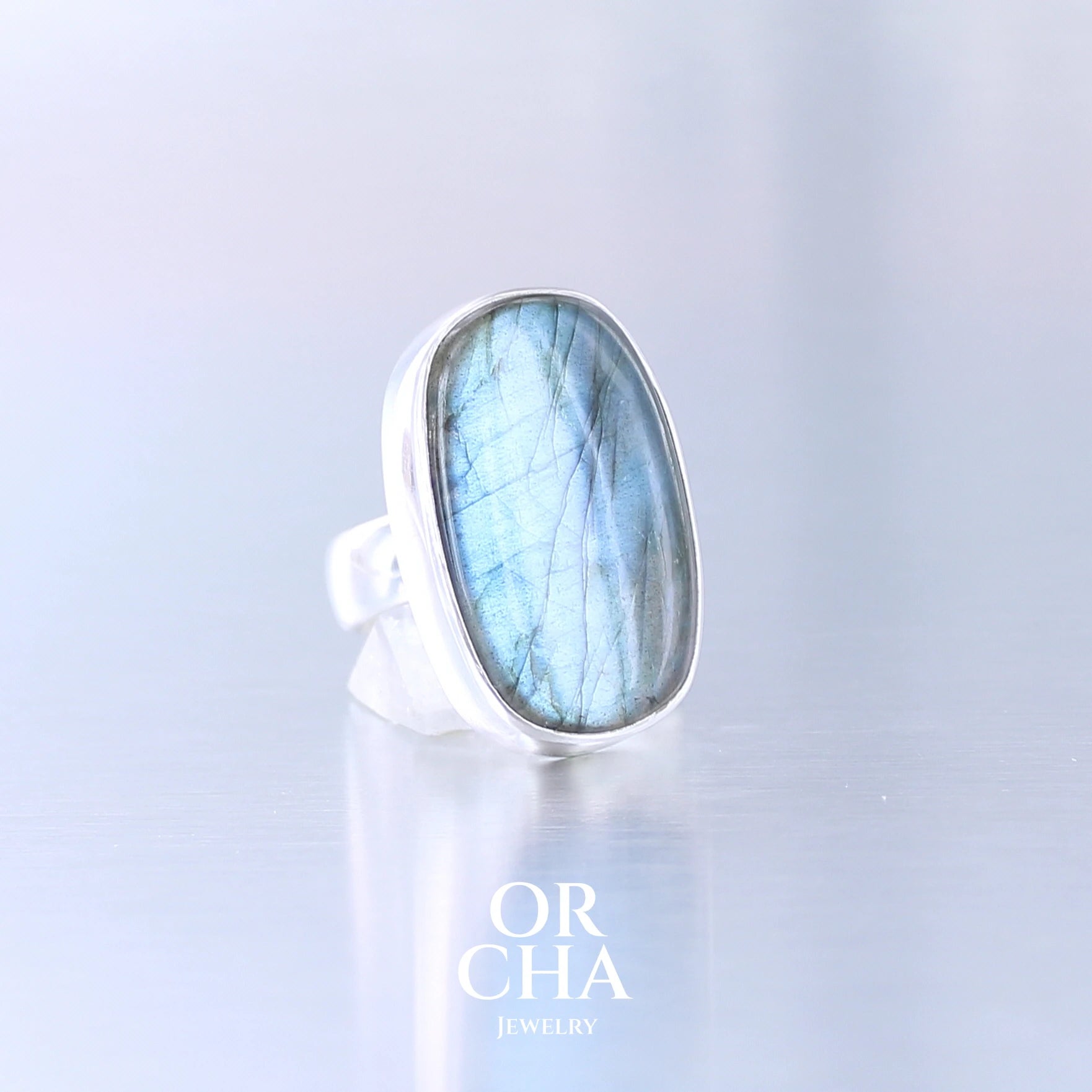 Bague unique pour femme en argent massif sertie d'une labradorite aux reflets bleus électrique selon la lumière. Pierre naturelle translucide présentant des inclusions fréquents sur ce type de pierre. Taille 60. Bijoux unique, éthique et durable présenté dans un coffret de notre marque, prêt à offrir. Livraison offerte, certificat d'authenticité, service client.