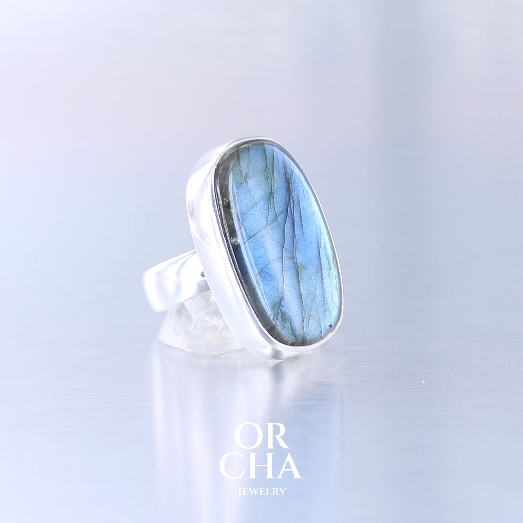 Bague unique pour femme en argent massif sertie d'une labradorite aux reflets bleus électrique selon la lumière. Pierre naturelle translucide présentant des inclusions fréquents sur ce type de pierre. Taille 60. Bijoux unique, éthique et durable présenté dans un coffret de notre marque, prêt à offrir. Livraison offerte, certificat d'authenticité, service client.