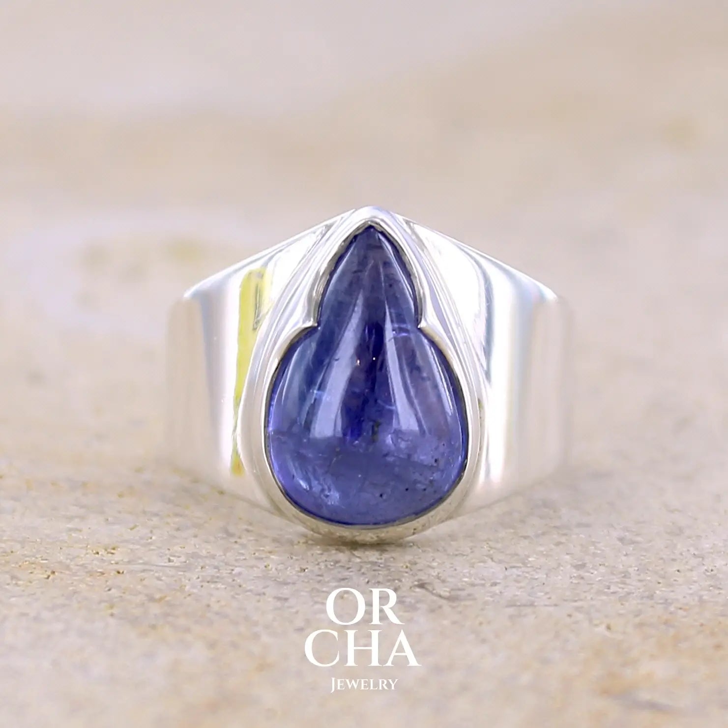 Grande Bague pour femme en argent massif, sertie d'un cabochon de tanzanite bleu lavande. Pierre taillée en forme de goutte. Pierre transparente comportant des inclusions. Taille 54. Bijoux unique, éthique et durable présenté dans un coffret de notre marque, prêt à offrir. Livraison offerte, certificat d'authenticité, service client.
