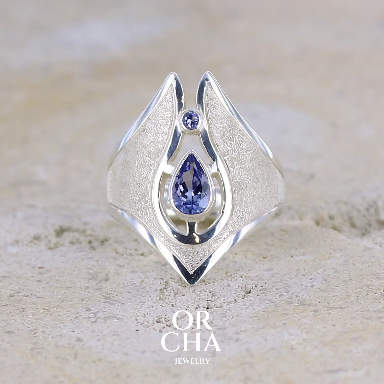 Grande Bague pour femme, fantaisy luxe en argent massif, sertie de tanzanites bleu lavande. Pierre facettée en forme de goutte et une plus petite ronde. Pierre  lumineuse et propre à l'oeil. Taille 59. Bijoux unique, éthique et durable présenté dans un coffret de notre marque, prêt à offrir. Livraison offerte, certificat d'authenticité, service client.
