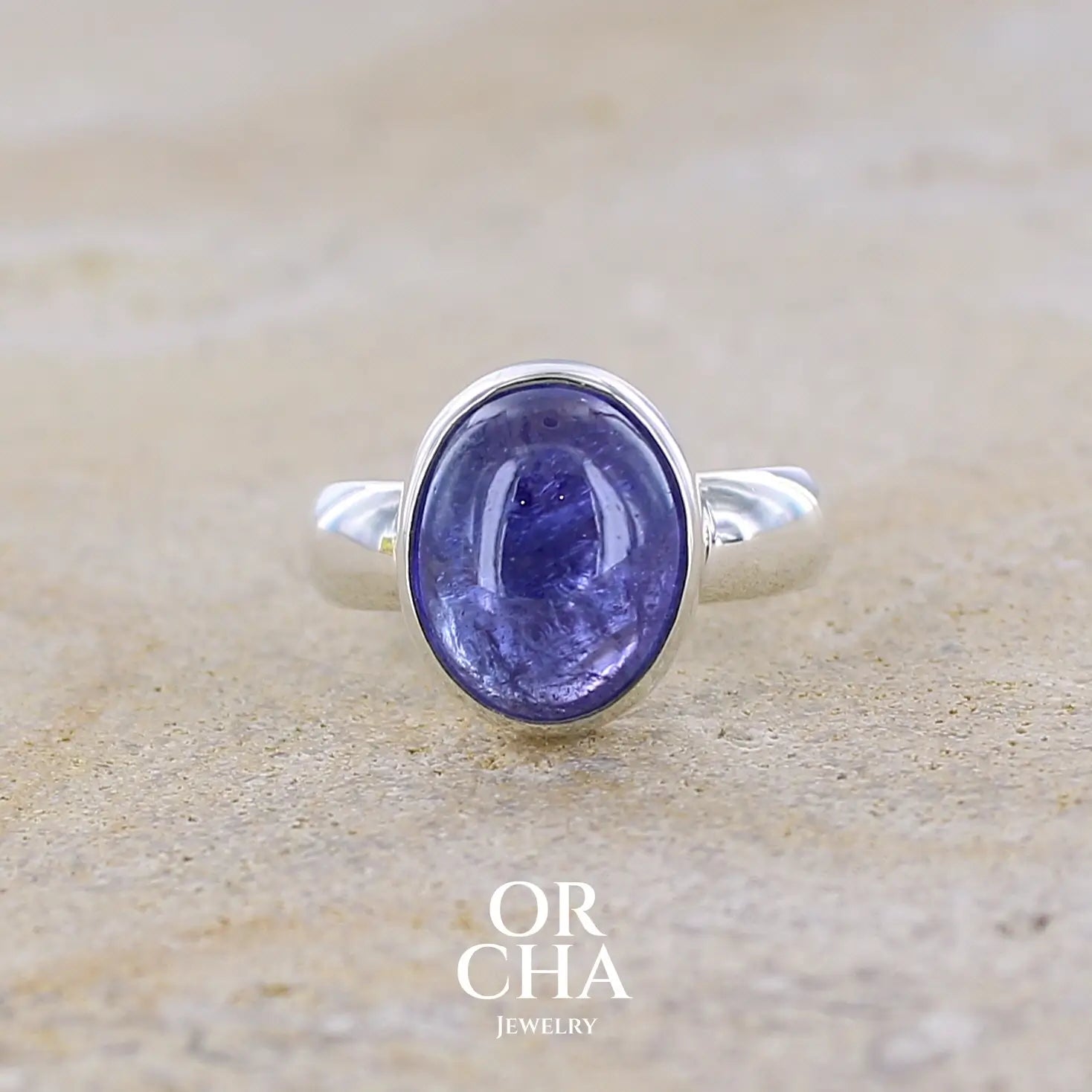 Bague pour femme en argent massif, sertie d'un cabochon de tanzanite bleu lavande. Cabochon de forme ovale. Pierre transparente comportant des inclusions. Taille 58. Bijoux unique, éthique et durable présenté dans un coffret de notre marque, prêt à offrir. Livraison offerte, certificat d'authenticité, service client.