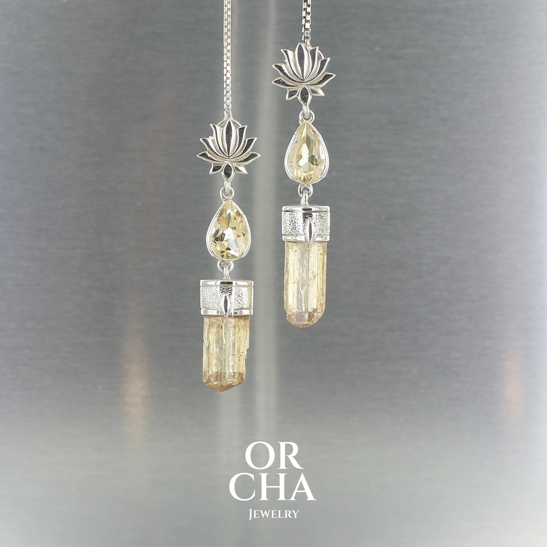 Boucles d’oreilles pendantes en argent : motif lotus au lobe, une citrine taillée en poire avec la pointe vers le haut et cristal brut de topaze impériale. Bijoux unique, éthique et durable présenté dans un coffret de notre marque, prêt à offrir. Livraison offerte, certificat d'authenticité, service client.
