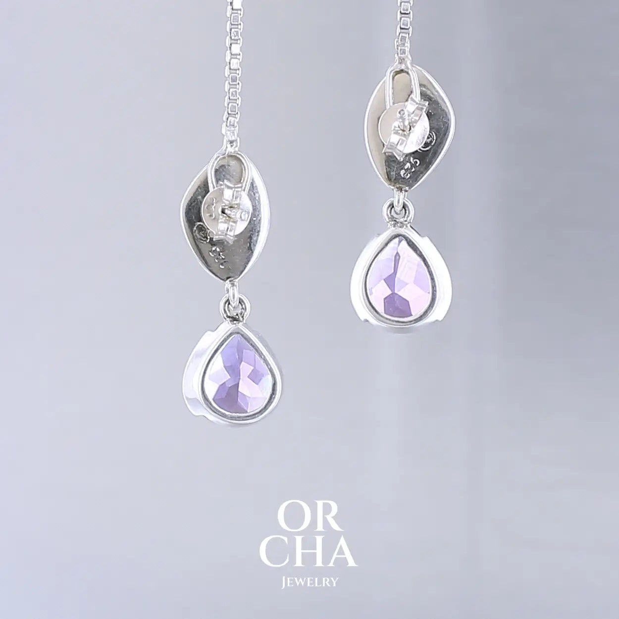 Boucles d'oreilles pendantes pour femme en argent massif serties d'Améthyste. Pierres facettées en forme de goutte de qualités transparentes, propre à l'oeil. Pierres naturelles de couleur violet moyen .Bijoux unique, éthique et durable présenté dans un coffret de notre marque, prêt à offrir. Livraison offerte, certificat d'authenticité, service client.