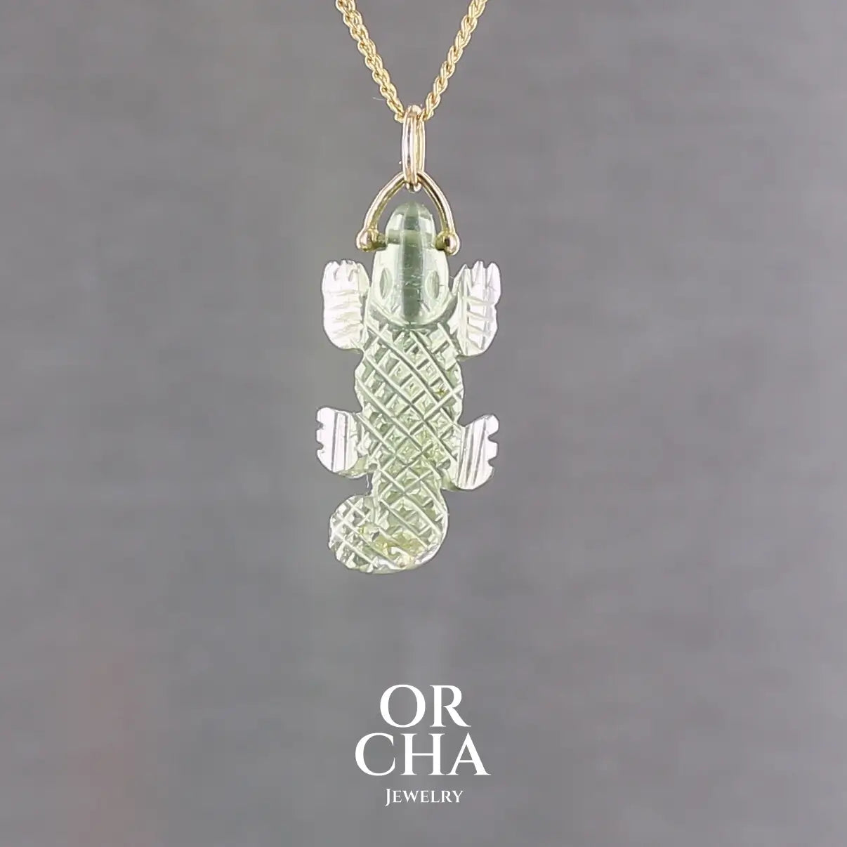 Collier pour homme orné d'une tourmaline verte sculptée à la main en 3 dimensions en forme de crocodile sertie en or 18k. Le pendentif est vendu sur une chaine de 45 cm de long en Gold filled ( or laminé ). Bijoux unique, éthique et durable présenté dans un coffret de notre marque, prêt à offrir. Livraison offerte, certificat d'authenticité, service client.
