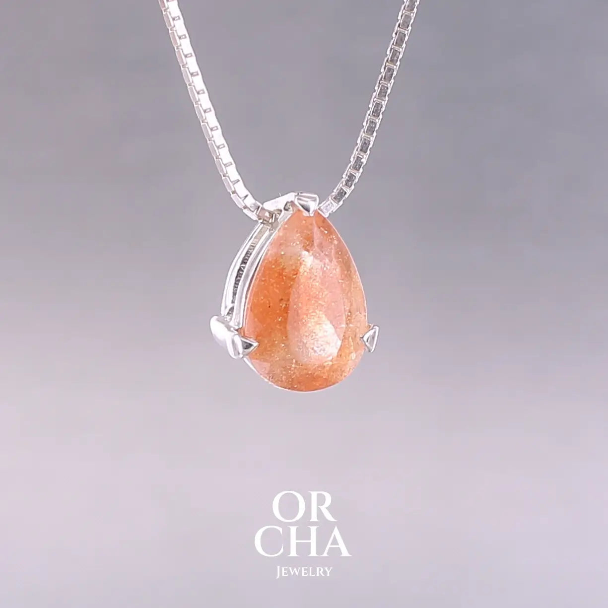 Collier solitaire pour femme en argent massif serti d'une pierre de soleil. Pierre de couleur orange facettée en forme de goutte, qualité transparente à  inclusions scintillantes dorées orangées. Pendentif monté sur une chaine en argent sterling de type maille carrée miroir de 0,94 mm d'épaisseur et de 40 cm de longueur. Bijoux unique, éthique et durable présenté dans un coffret de notre marque, prêt à offrir. Livraison offerte, certificat d'authenticité, service client.
