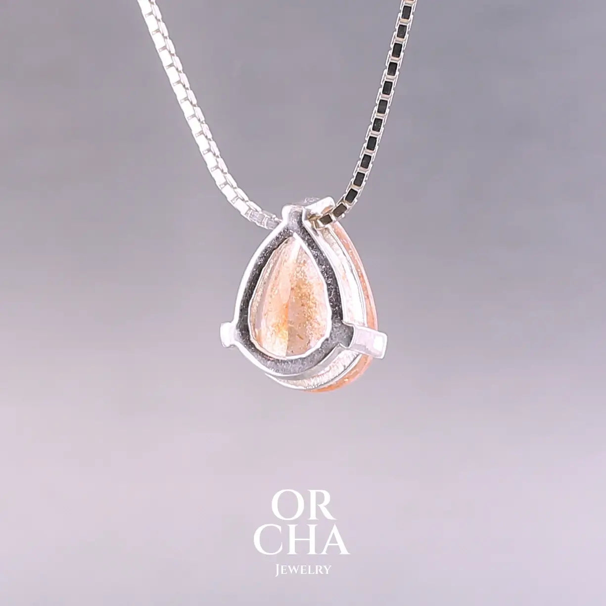 Collier solitaire pour femme en argent massif serti d'une pierre de soleil. Pierre de couleur orange facettée en forme de goutte, qualité transparente à  inclusions scintillantes dorées orangées. Pendentif monté sur une chaine en argent sterling de type maille carrée miroir de 0,94 mm d'épaisseur et de 40 cm de longueur. Bijoux unique, éthique et durable présenté dans un coffret de notre marque, prêt à offrir. Livraison offerte, certificat d'authenticité, service client.
