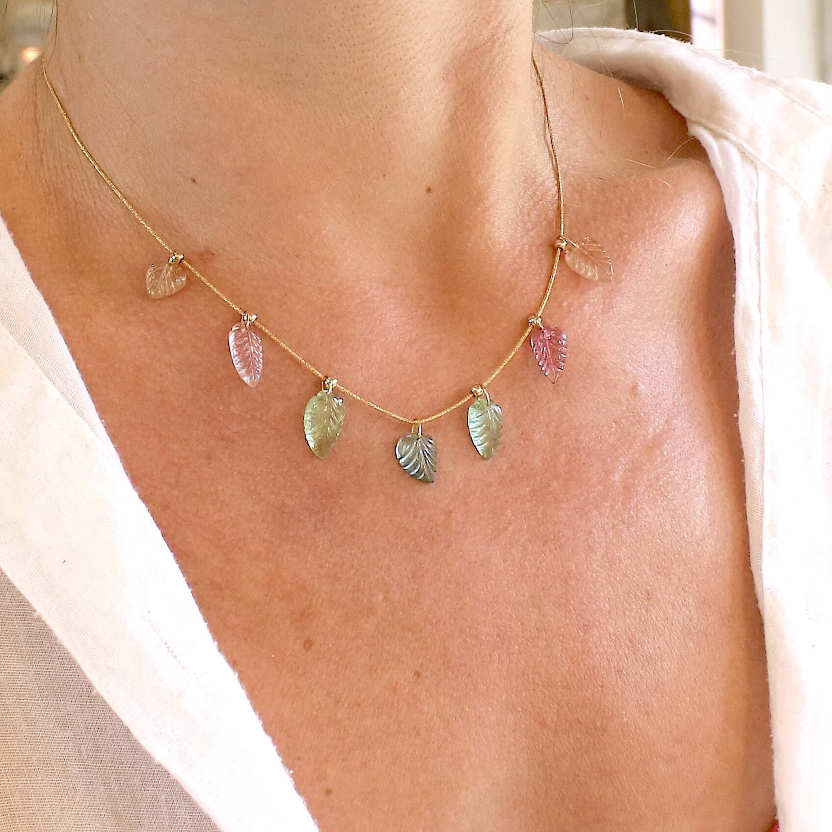 Collier pour femme orné de tourmalines roses, vertes, bleues et pêches, sculptées à la main en 3 dimensions en forme de feuilles et serties en or 18k. Les pendentifs sont montés sur un collier corde doré scintillant, les apprêts utilisé sont en Gold filled ( or laminé ). Longueur ajustable de 40 cm à 45 cm. Bijoux unique, éthique et durable présenté dans un coffret de notre marque, prêt à offrir. Livraison offerte, certificat d'authenticité, service client.