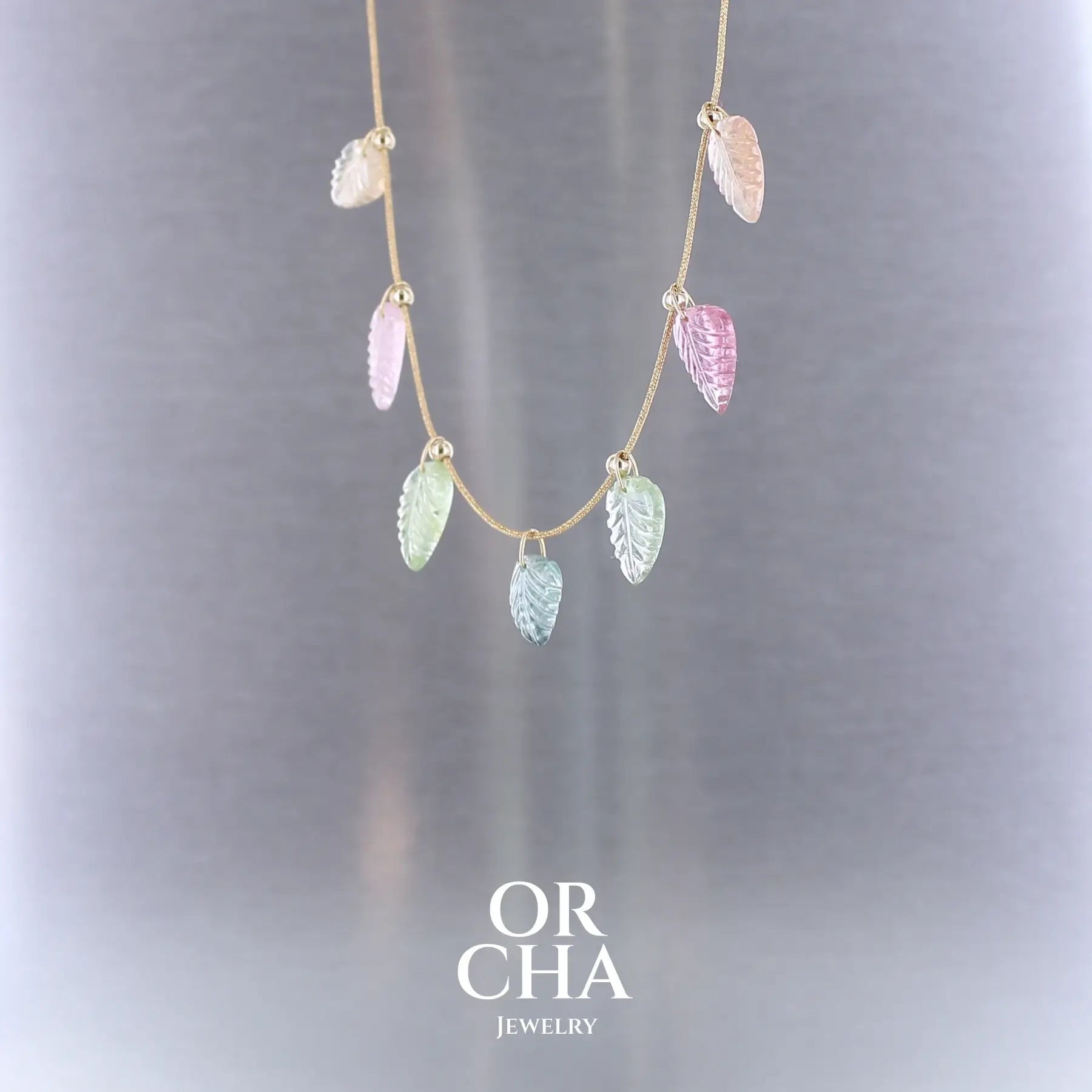 Collier pour femme orné de tourmalines roses, vertes, bleues et pêches, sculptées à la main en 3 dimensions en forme de feuilles et serties en or 18k. Les pendentifs sont montés sur un collier corde doré scintillant, les apprêts utilisé sont en Gold filled ( or laminé ). Longueur ajustable de 40 cm à 45 cm. Bijoux unique, éthique et durable présenté dans un coffret de notre marque, prêt à offrir. Livraison offerte, certificat d'authenticité, service client.