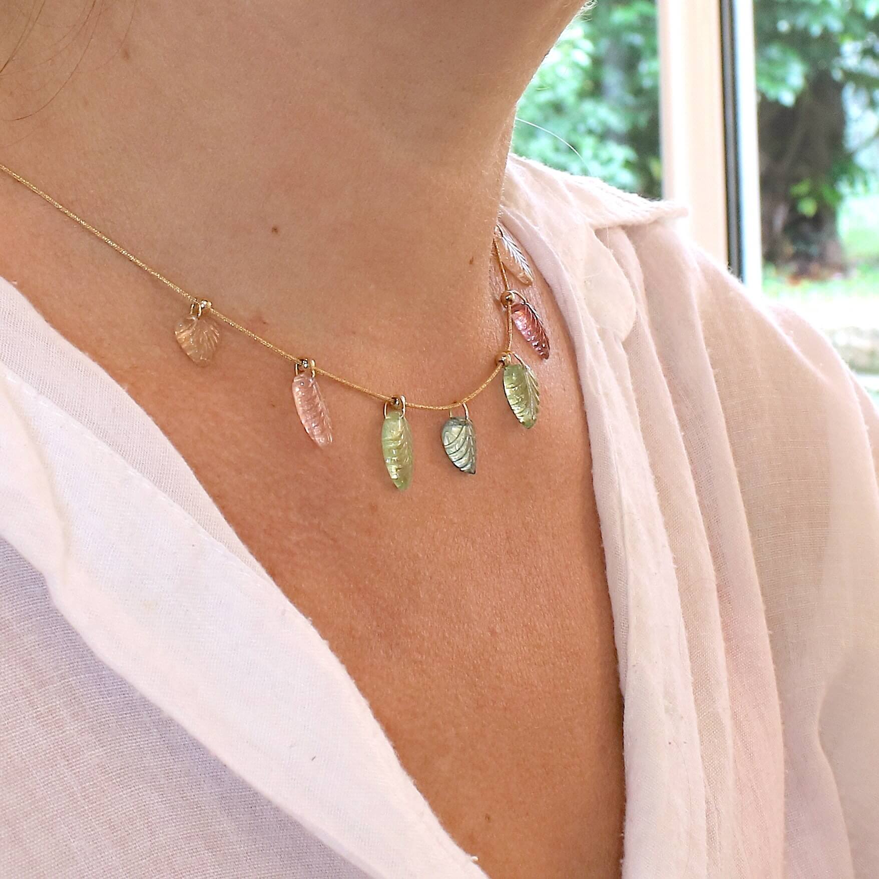 Collier pour femme orné de tourmalines roses, vertes, bleues et pêches, sculptées à la main en 3 dimensions en forme de feuilles et serties en or 18k. Les pendentifs sont montés sur un collier corde doré scintillant, les apprêts utilisé sont en Gold filled ( or laminé ). Longueur ajustable de 40 cm à 45 cm. Bijoux unique, éthique et durable présenté dans un coffret de notre marque, prêt à offrir. Livraison offerte, certificat d'authenticité, service client.