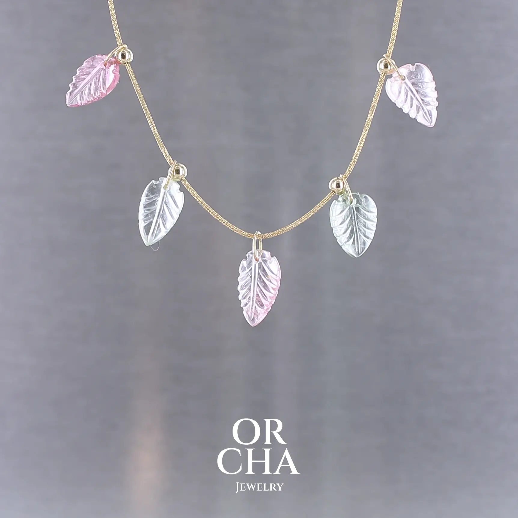 Collier pour femme orné de tourmalines roses et vertes sculptées à la main en 3 dimensions en forme de feuilles serties en or 18k. Les breloques sont montées sur un collier corde doré scintillant, les apprêts utilisé sont en Gold filled ( or laminé ). Longueur ajustable de 40 cm à 45 cm. Bijoux unique, éthique et durable présenté dans un coffret de notre marque, prêt à offrir. Livraison offerte, certificat d'authenticité, service client.
