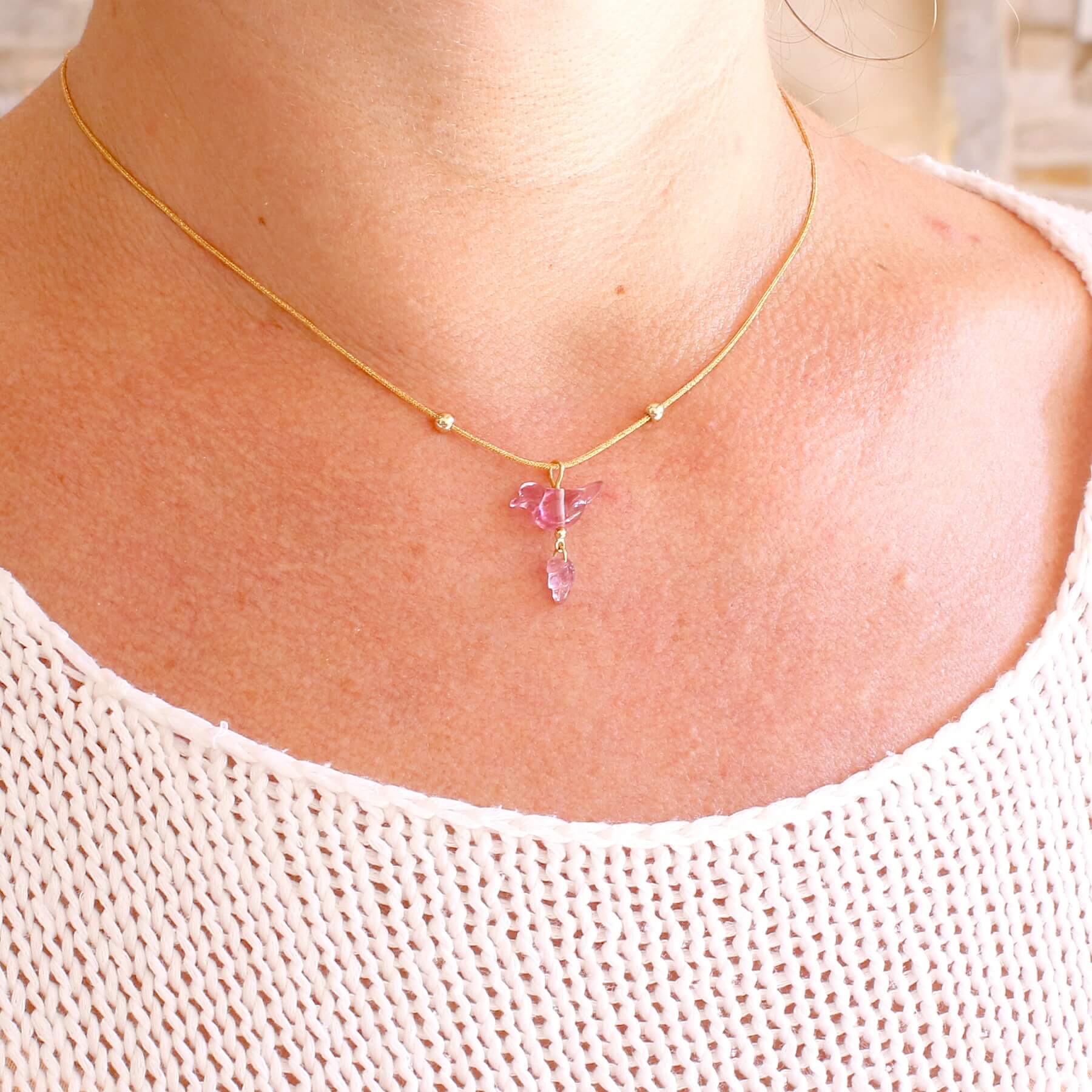 Collier pour femme orné d'une tourmaline rose sculptée à la main en 3 dimensions en forme d'oiseau et de feuille, serties en or 18k. Le pendentif est monté sur un collier corde doré scintillant, les apprêts utilisé sont en Gold filled ( or laminé ). Longueur ajustable de 40 cm à 45 cm. Bijoux unique, éthique et durable présenté dans un coffret de notre marque, prêt à offrir. Livraison offerte, certificat d'authenticité, service client.
