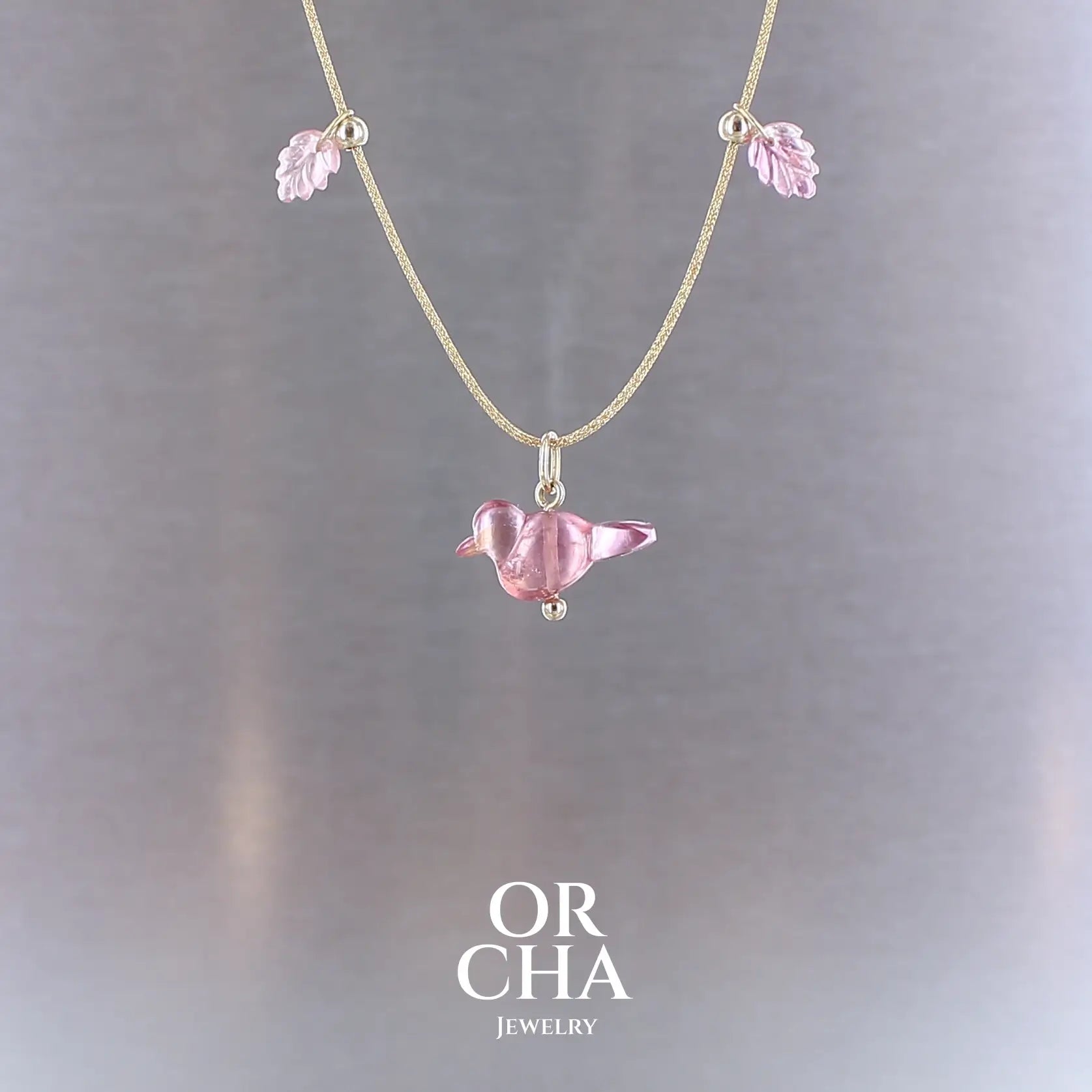 Collier pour femme orné de tourmalines roses sculptées à la main en 3 dimensions en forme d'oiseau et de feuilles, serties en or 18k. Les pendentifs sont montés sur un collier corde doré scintillant, les apprêts utilisé sont en Gold filled ( or laminé ). Longueur ajustable de 40 cm à 45 cm. Bijoux unique, éthique et durable présenté dans un coffret de notre marque, prêt à offrir. Livraison offerte, certificat d'authenticité, service client.
