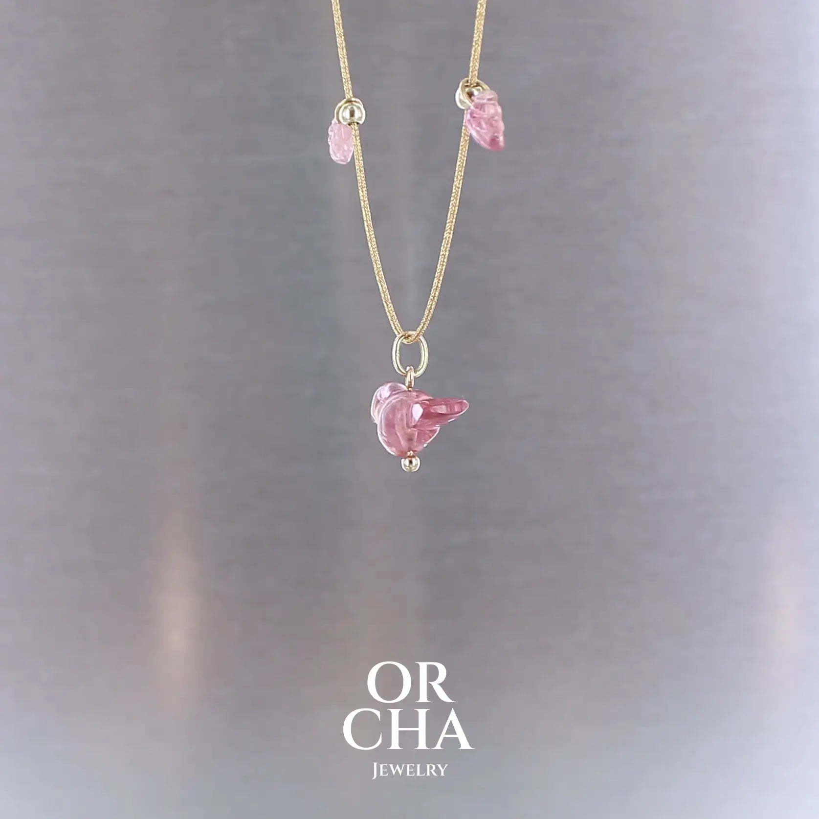 Collier pour femme orné de tourmalines roses sculptées à la main en 3 dimensions en forme d'oiseau et de feuilles, serties en or 18k. Les pendentifs sont montés sur un collier corde doré scintillant, les apprêts utilisé sont en Gold filled ( or laminé ). Longueur ajustable de 40 cm à 45 cm. Bijoux unique, éthique et durable présenté dans un coffret de notre marque, prêt à offrir. Livraison offerte, certificat d'authenticité, service client.