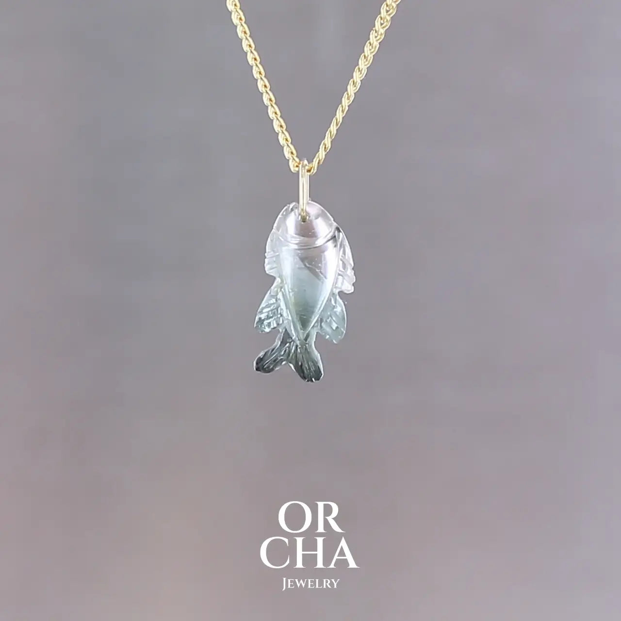 Collier pour femme orné d'une tourmaline bleue sculptée à la main en 3 dimensions en forme de poisson sertie en or 18k. Le pendentif est monté sur une chaine en Gold filled ( or laminé ) d'une longueur de 45 cm. Bijoux unique, éthique et durable présenté dans un coffret de notre marque, prêt à offrir. Livraison offerte, certificat d'authenticité, service client.
