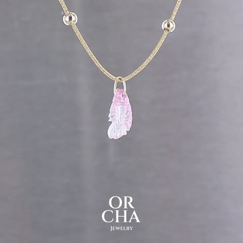 Collier pour femme orné d'une tourmaline rose sculptée à la main en 3 dimensions en forme de poisson sertie en or 18k. Le pendentif est monté sur un collier corde doré scintillant, les apprêts utilisé sont en Gold filled ( or laminé ). Longueur ajustable de 40 cm à 45 cm. Bijoux unique, éthique et durable présenté dans un coffret de notre marque, prêt à offrir. Livraison offerte, certificat d'authenticité, service client.