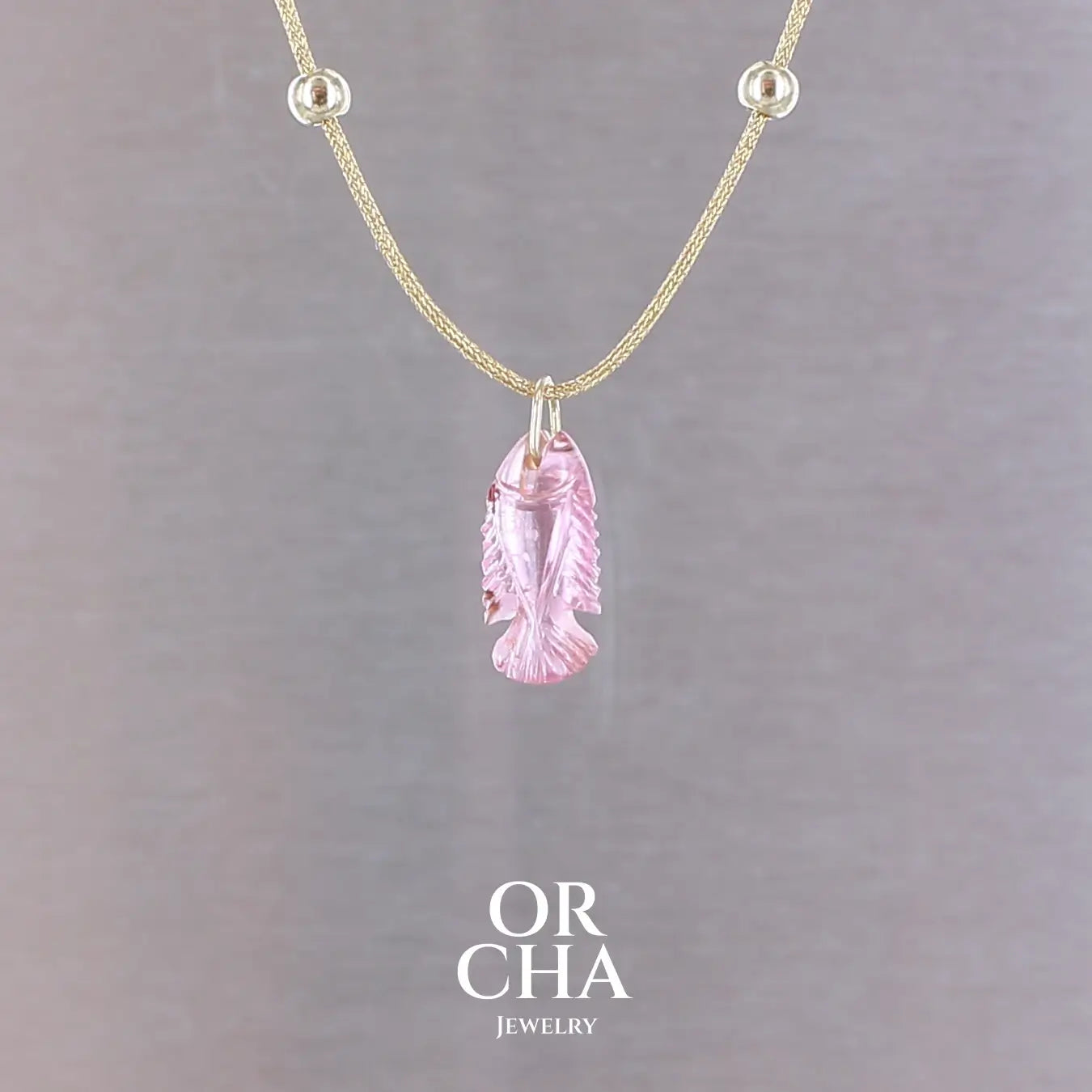 Collier pour femme orné d'une tourmaline rose sculptée à la main en 3 dimensions en forme de poisson sertie en or 18k. Le pendentif est monté sur un collier corde doré scintillant, les apprêts utilisé sont en Gold filled ( or laminé ). Longueur ajustable de 40 cm à 45 cm. Bijoux unique, éthique et durable présenté dans un coffret de notre marque, prêt à offrir. Livraison offerte, certificat d'authenticité, service client.
