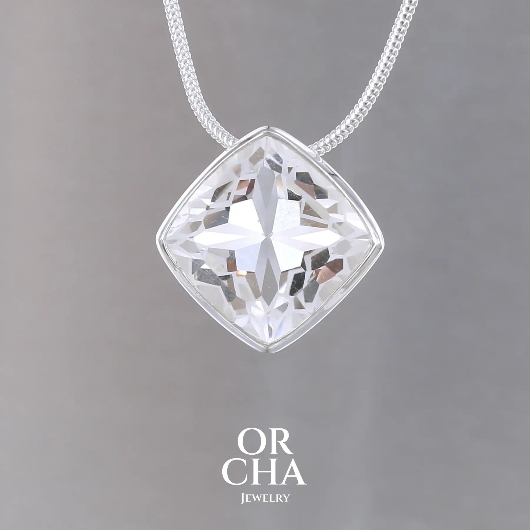 collier solitaire pour femme en argent massif sertie d'un Cristal de roche gravé d'une fleur de vie. Pierre facettée de forme carrée de qualité transparente, propre à l'oeil. Pierre naturelle incolore et blanche sur les parties gravées. Pendentif monté sur une chaine en argent sterling de type maille serpent de 1,2 mm d'épaisseur et de 40 cm de longueur. Bijoux unique, éthique et durable présenté dans un coffret de notre marque, prêt à offrir. Livraison offerte, certificat d'authenticité, service client.