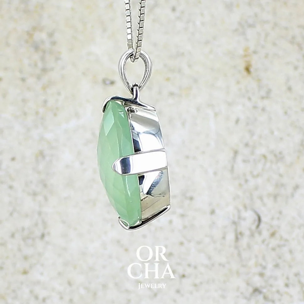 détail sertissage d'un pendentif ovale en argent massif, serti d'un cabochon facetté de préhnite de couleur verte jaune pastel. Pierre de qualité translucide comportant des inclusions. Bijoux unique par Orcha Jewelry