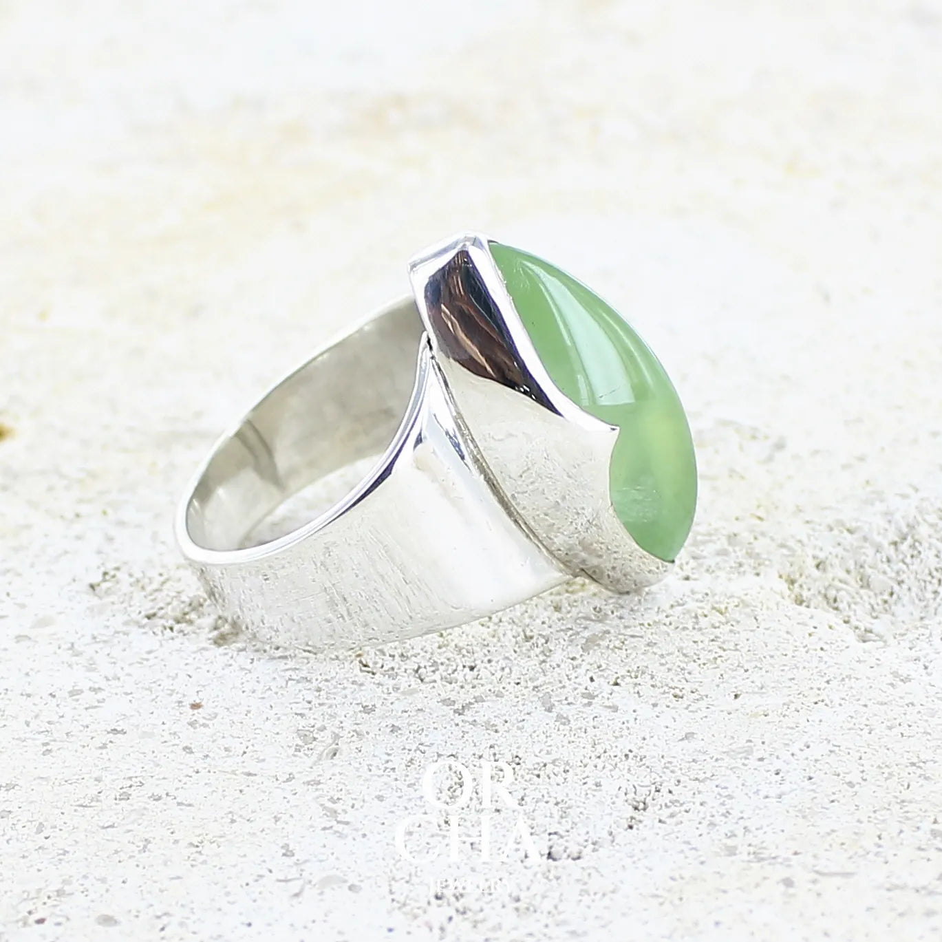 détail sertissage d'une bague marquise pour femme en argent massif sertie d'une préhnite de couleur verte jaune clair, Pierre taillée en cabochon en forme de goutte. Pierre gemme de qualité transparente à inclusions. Bijoux unique réalisé en taille 60 par Orchajewelry.