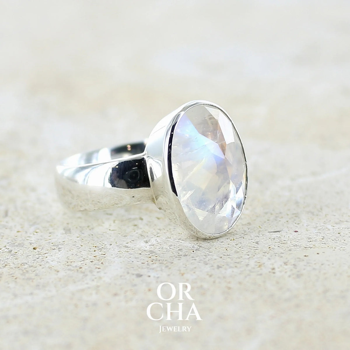 Détail de l'anneau d'une Bague cocktail pour femme en argent massif 925 sertie d'une Labradorite blanche taillée de 6,7 carats incolore aux reflets bleutés et arc en ciel. Pierre transparente avec inclusions. Bijoux unique réalisée en taille 57 par Orchajewelry