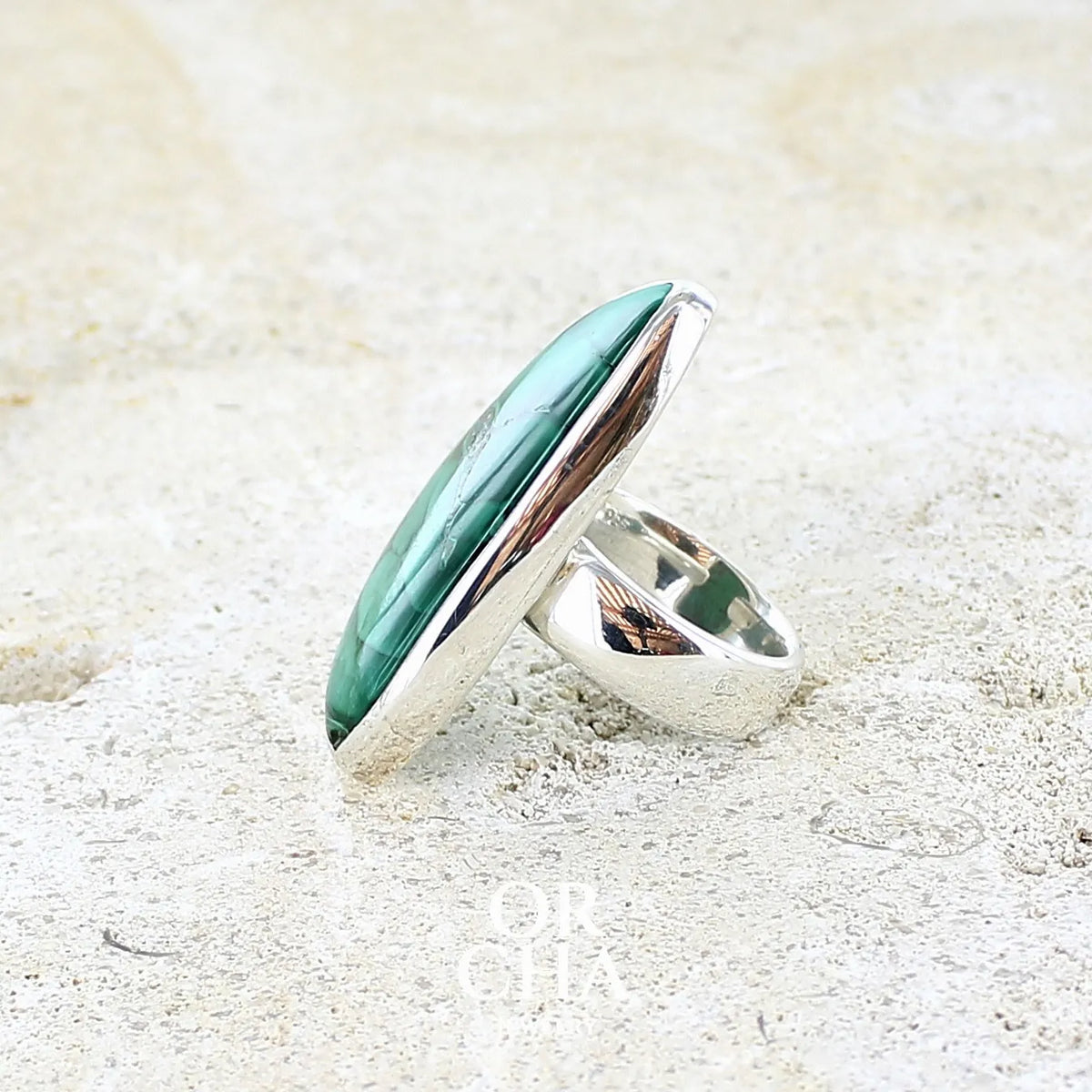 détail du sertissage d'une bague pour femme en argent massif sertie d'un cabochon de Malachite aux couleurs nuancées vertes profondes intenses. Bijoux unique réalise en taille 54 par Orchajewelry 