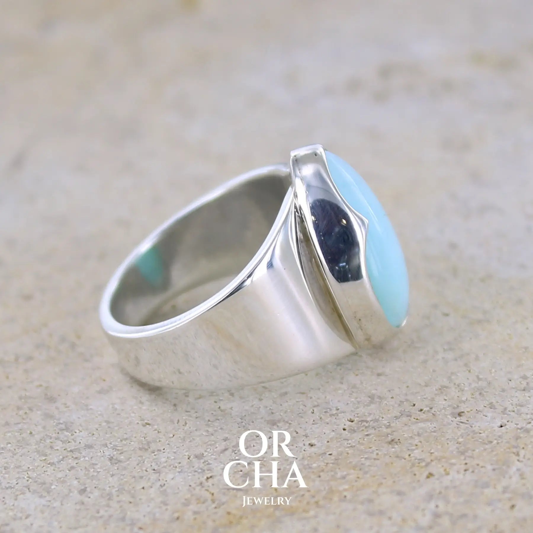 detail sertissage d'une bague pour femme en argent massif sertie d'une Opale bleue du Pérou. Pierre naturelle de couleur bleu ciel, taillée en cabochon en forme de goutte, de qualité opaque. Taille 51. Bijoux unique, éthique et durable présenté dans un coffret de notre marque, prêt à offrir. Livraison offerte, certificat d'authenticité, service client.
