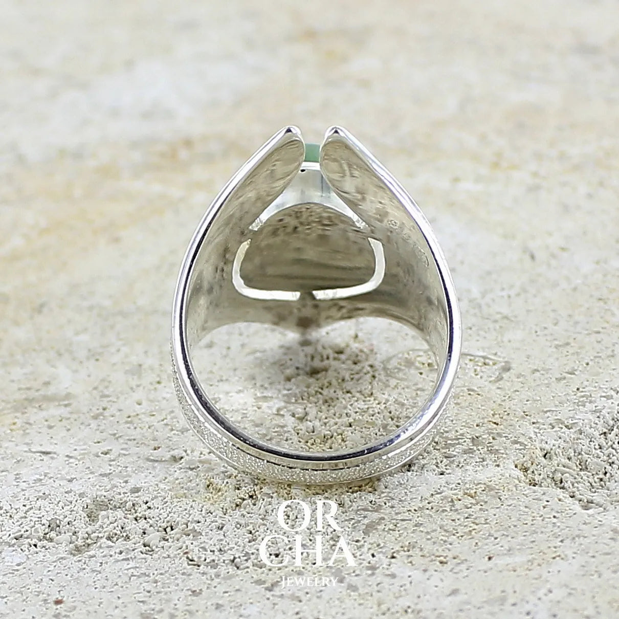 vue de dos d'une Grande bague pour femme en argent massif sertie d'une préhnite de couleur verte jaune clair, Pierre taillée en cabochon en forme de goutte. Pierre gemme de qualité transparente à inclusions. Bijoux unique réalisé en taille 59 par Orchajewelry.