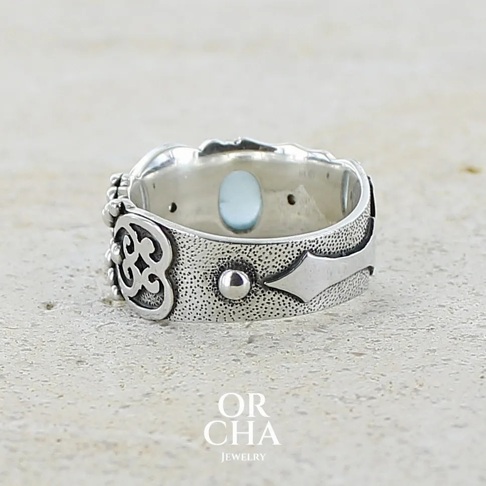 Vue de dos d'un bague anneau pour homme en argent massif d'inspiration celtique, médiévale. Bague sertie d'un cabochon d'aigue-marine de couleur bleu gris. Pierre  translucide propre à l'oeil. Bijou unique réalisé en taille 58. 