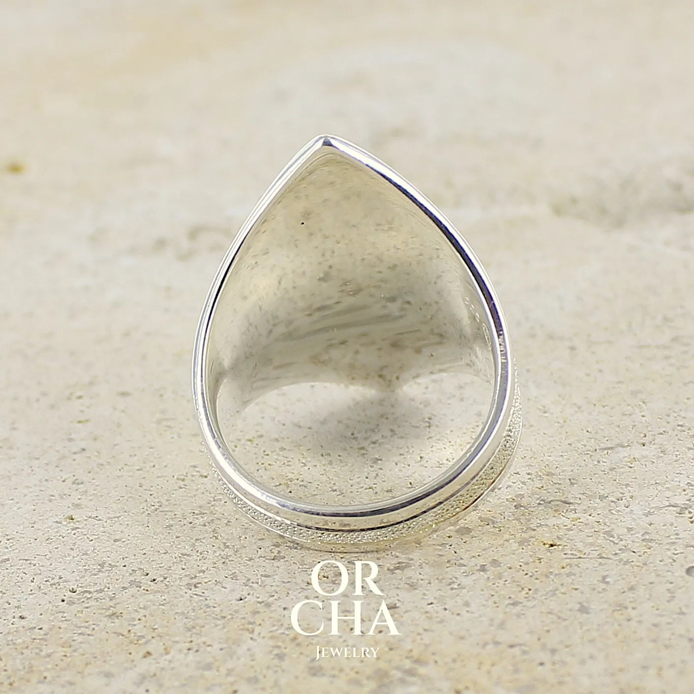 vue de dos d'une bague étoile pour femme en argent massif, sertie d'un cabochon de calcédoine bleue verte. Pierre taillée de en forme de goutte. Pierre translucide. bijou unique réalisée en taille 59 par Orcha Jewelry