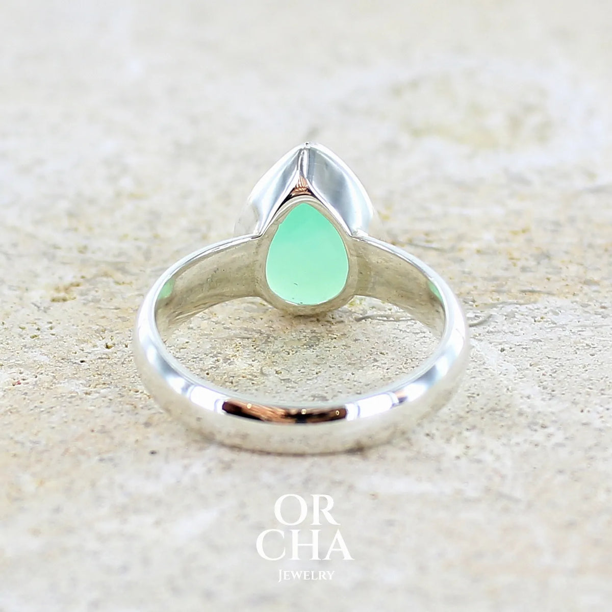 dos d'une bague pour femme en argent massif sertie d'un cabochon de chrysoprase de couleur vert émeraude pastel. Pierre translucide taillée en forme de goutte. Bijou unique réalisé en taille 58 par Orcha Jewelry